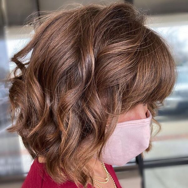 Angled Wavy Hair - a woman wearing red blouse with pink mask.