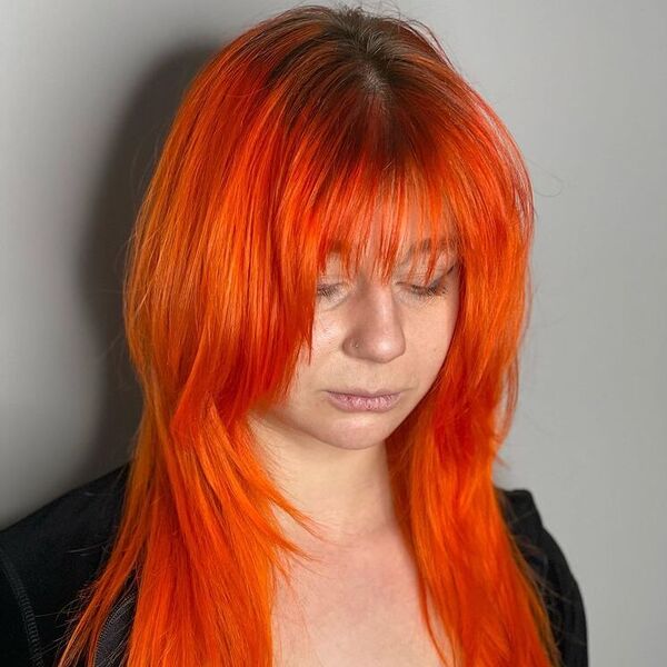 Bright Orange Wispy Bangs in Layers - a woman wearing black top.