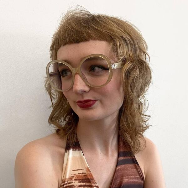 Modern Mullet Wispy Bangs - a woman wearing glasses in tank top.