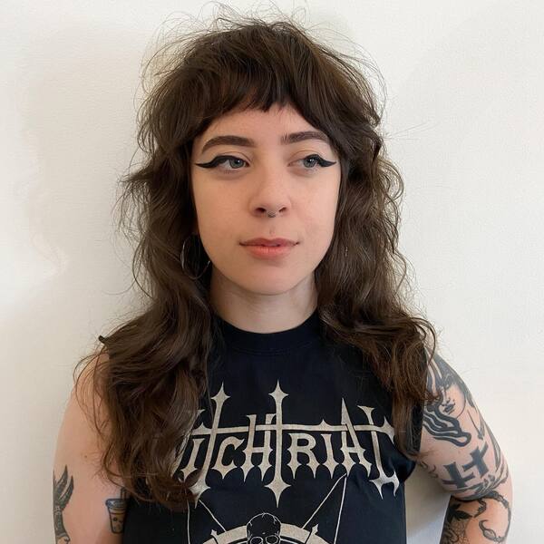 Modern Shag Mullet Wispy Fringes - a woman wearing sleeveless top with body tattoo.