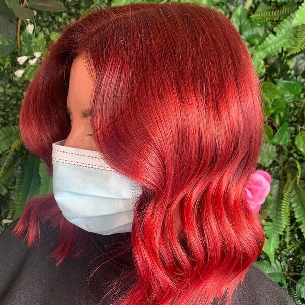 Shiny Vibrant Red on Wavy Hair - a woman wearing mask and black shirt.