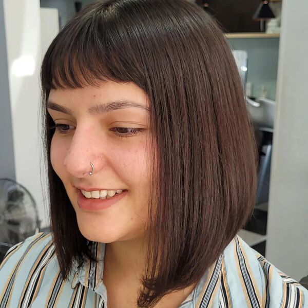 Shoulder Length Bob with Blunt Bangs - a woman wearing stripe polo.