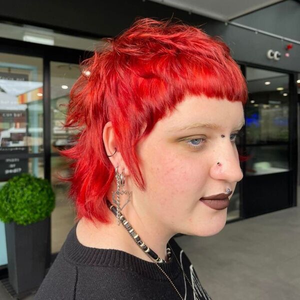 Hot Red Pixie Mullet - a woman wearing black shirt with punky accessories.