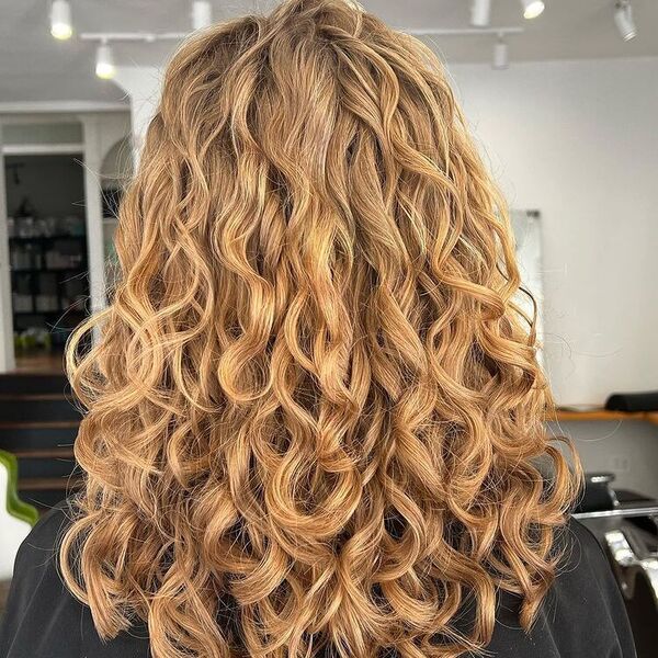 Natural Curls Strawberry Blonde - a woman wearing black cape.