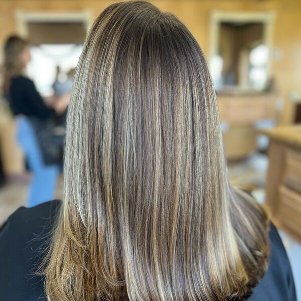Straightened Honey Brown Highlights - a woman wearing black cape.