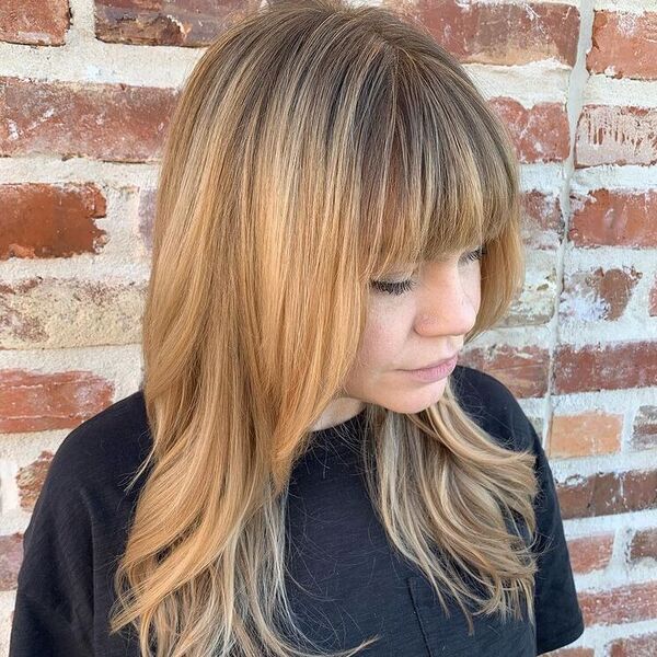 Strawberry Honey Tones with Bangs - a woman wearing black shirt.